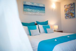 a bedroom with a bed with blue and white pillows at Sea view Belle Haven Penthouse in Mont Choisy