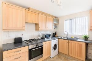 a kitchen with wooden cabinets and a stove top oven at 5 Bedroom Home Stay in Wolverhampton