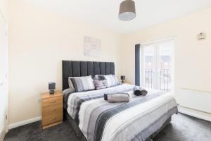 a bedroom with a large bed and a window at 5 Bedroom Home Stay in Wolverhampton