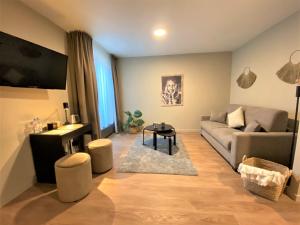 a living room with a couch and a table at Bloomhotel in Lochristi