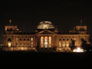 a large building with a glass dome at night at Apartment&Rooms near Brandenburg Gate in Berlin