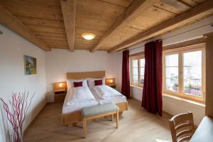 a bedroom with a bed and two windows at La Maison Salvagny in Murten