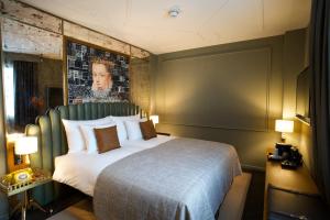 a hotel room with a bed and a dresser at The Collector in The Hague