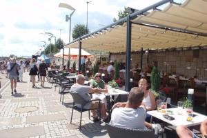 a group of people sitting at tables on a patio at CityCorner Appartment in Szczecin