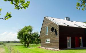 uma casa de madeira com um telhado de gambrel em Solar-Ligna em Mildenitz
