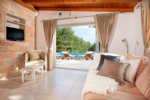 a living room with a couch and a large window at Villa Zlatni Rat with pool by the beach Zlatni rat in Bol - Brac in Bol