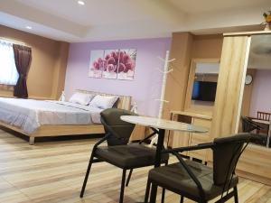 a bedroom with a bed and a table and chairs at Concordia Guesthouse in Jomtien Beach