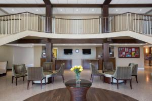 a lobby with a table and chairs and a staircase at Ramada by Wyndham Venice Hotel Venezia in Venice