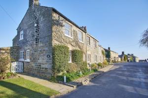 an old brick building with ivy on the side of a street at Host & Stay - Tithe Cottage in Harrogate