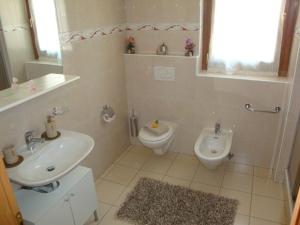 a bathroom with a sink and a toilet at Casa Lucini in Campascio