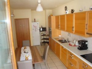 una cucina con mobili in legno e un tavolo al suo interno di Casa Lucini a Campascio