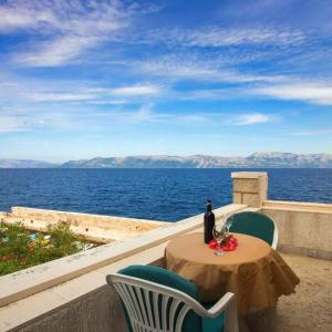 una mesa y sillas con una botella de vino en el balcón en Guest House Hazdovac en Kozarica