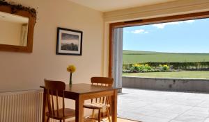 a dining room with a table and chairs and a window at Chapel of Barras B&B in Stonehaven