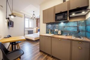 a kitchen with brown cabinets and a table in a room at Secret Apartments in Kyiv