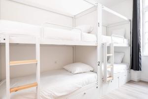 um beliche branco com beliches brancos em Le Couvent - Hostel em Carcassonne