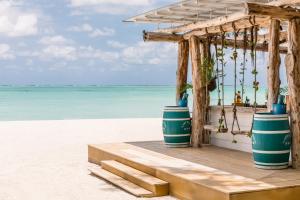 a beach bar with two blue and white barrels at Four Seasons Resort Mauritius at Anahita in Beau Champ