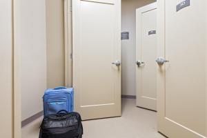 a blue suitcase and a bag in a hallway at Staybridge Suites - Miami International Airport by IHG in Miami