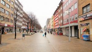 a person walking down a street in a city at Maye Oberhausen City Deluxe in Oberhausen