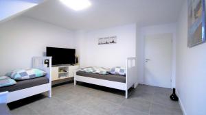 1 Schlafzimmer mit 2 Etagenbetten und einem Flachbild-TV in der Unterkunft Maye Oberhausen City Deluxe in Oberhausen