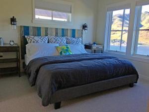 a bedroom with a large bed and two windows at Arroyo #60 in Chelan +30 photos