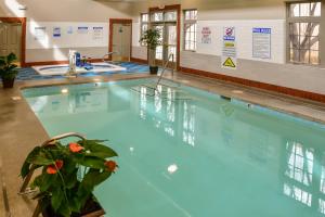 a swimming pool with blue water in a building at Fort Marcy Suites in Santa Fe