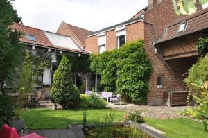 une maison avec un jardin dans la cour dans l'établissement Chambres privées chez le particulier aéroport Lille Lesquin, à Lesquin