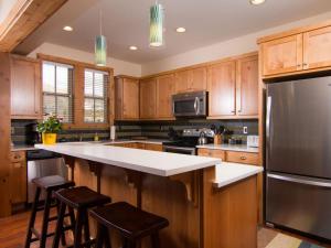 a kitchen with wooden cabinets and a black refrigerator at Chinook & Carriage House #2 in Chelan