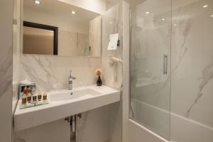 a bathroom with a sink, mirror and bath tub at Continental Hotel Budapest in Budapest