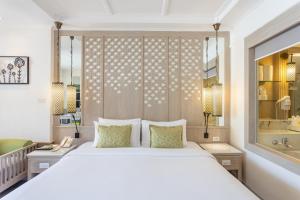 ein Schlafzimmer mit einem großen weißen Bett und einer Badewanne in der Unterkunft Katathani Phuket Beach Resort - SHA Extra Plus in Kata Beach