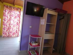 a room with a bunk bed with a tv on the wall at Au Sable D'Or - Spa - WIfi- Piscine in Deshaies