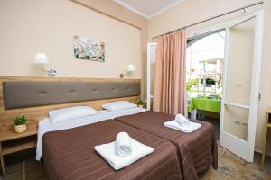 una camera da letto con un grande letto con asciugamani di Stavros Apartments Kontokali next to Gouvia Marina a Kontokali