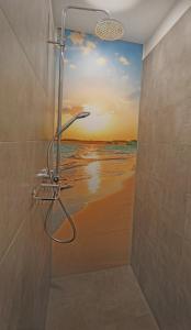 a bathroom with a shower with a painting of the ocean at CityPension-Vreden in Vreden