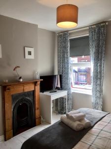 a bedroom with a bed with a fireplace and a television at THE LIMES Guest House in Birmingham