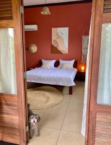 a dog standing in a bedroom with a bed at Villa Jonquet in Parajuru