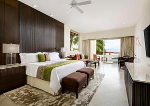Grand Velas Riviera Nayarit في نويفو فايارتا: غرفة نوم بسرير كبير وغرفة معيشة