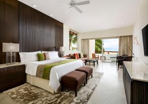 a bedroom with a large bed and a living room at Grand Velas Riviera Nayarit in Nuevo Vallarta 