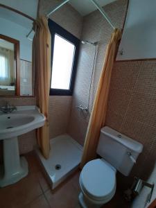łazienka z toaletą, umywalką i oknem w obiekcie Atico De Amplias Terrazas En Zahara Pueblo w mieście Zahara de los Atunes