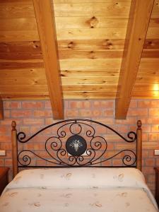 a bedroom with a black bed with a wooden ceiling at Casa Feixas in Gistaín