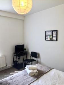 a bedroom with a bed with a desk and a chair at Summerfield House in Birmingham