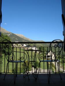 a balcony with chairs and a view of a field at Casa Feixas in Gistaín