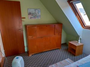 - une chambre mansardée avec une commode en bois dans l'établissement Høkeriet C, à Nordborg