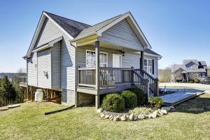 une petite maison avec un porche et une terrasse dans l'établissement KY Cottage, with hot tub and lake view, on the Bourbon Trail, à Taylorsville
