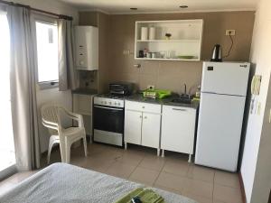 een kleine keuken met een witte koelkast en een tafel bij Monoambiente cálido en el corazón de Concordia in Concordia
