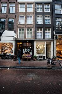 une personne marchant devant un bâtiment dans l'établissement Bed & Breakfast The 9 Streets, à Amsterdam