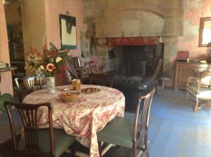 Le Carroy Brion في Cinais: غرفة طعام مع طاولة ومدفأة