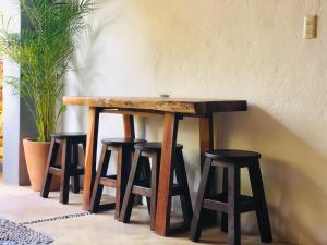 a wooden table with four stools around it at Refugio del Cielo # in Sayulita