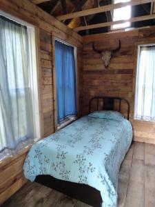 a bedroom with a bed in a log cabin at Auberge Carpe Diem in Baie-Saint-Paul