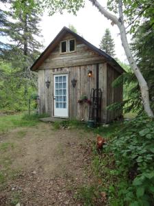 a small wooden shed with a chicken in front of it at Auberge Carpe Diem in Baie-Saint-Paul