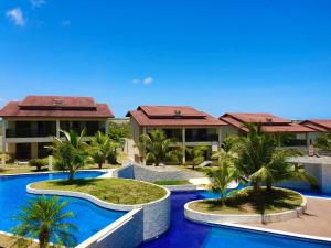 a view of a resort with palm trees and a swimming pool at Riviera de Praia Bela in Pitimbu