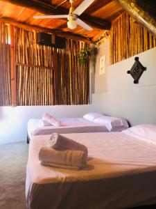 three beds in a room with wooden ceilings at Refugio del Cielo # in Sayulita